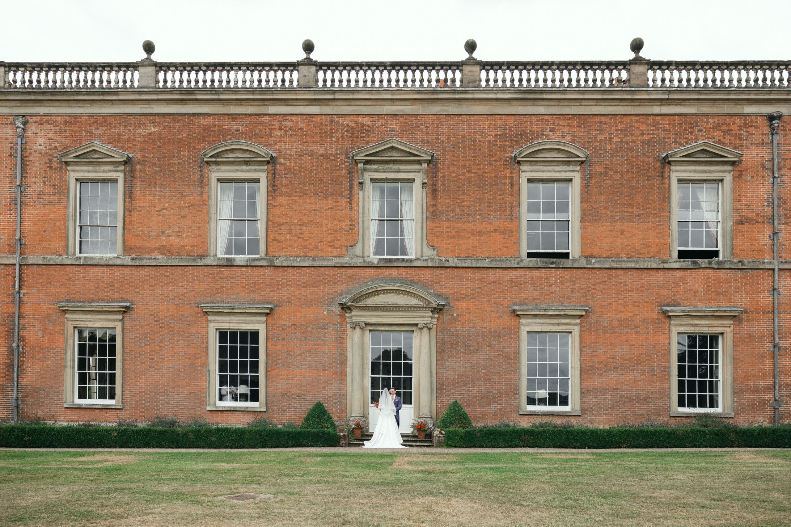 Romantic portrait of newlyweds in front of Staunton Harold Hall’s architecture