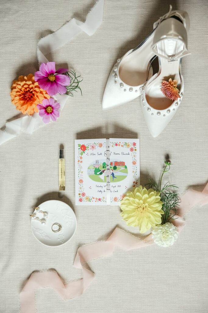 Flatlay photo, wedding invitation, shoes, rings, jewellery all laid out.