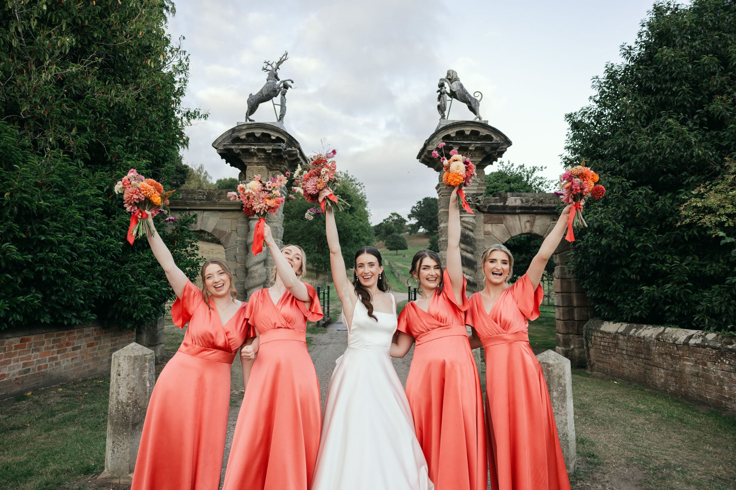 Bride with bridesmaids holding colourful bouquets at Staunton Harold Hall