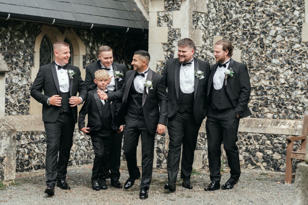 Groomsmen posing together outside St Paul’s Church Gorefield before the ceremony