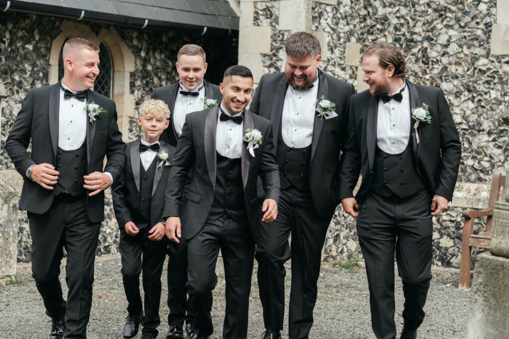 Groomsmen posing together outside St Paul’s Church Gorefield before the ceremony