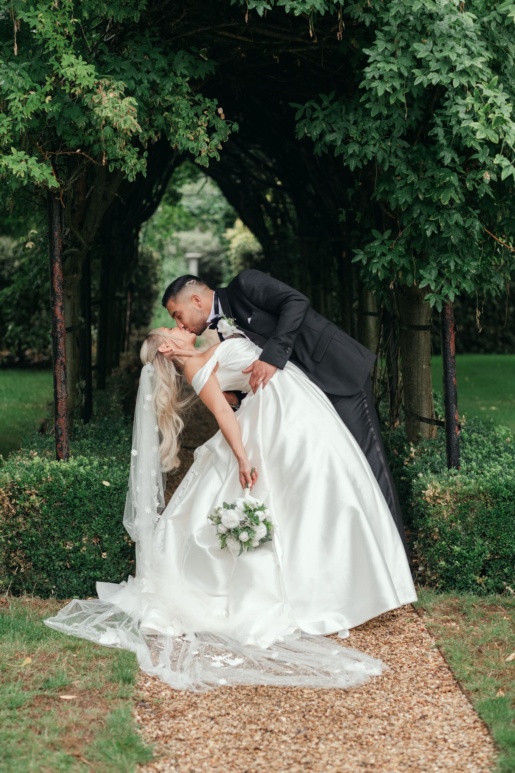 Newlywed couple posing for portraits in the gardens at The Hop Rooms in Wisbech