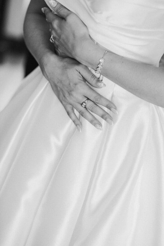 Close-up of the wedding dress and brides hands