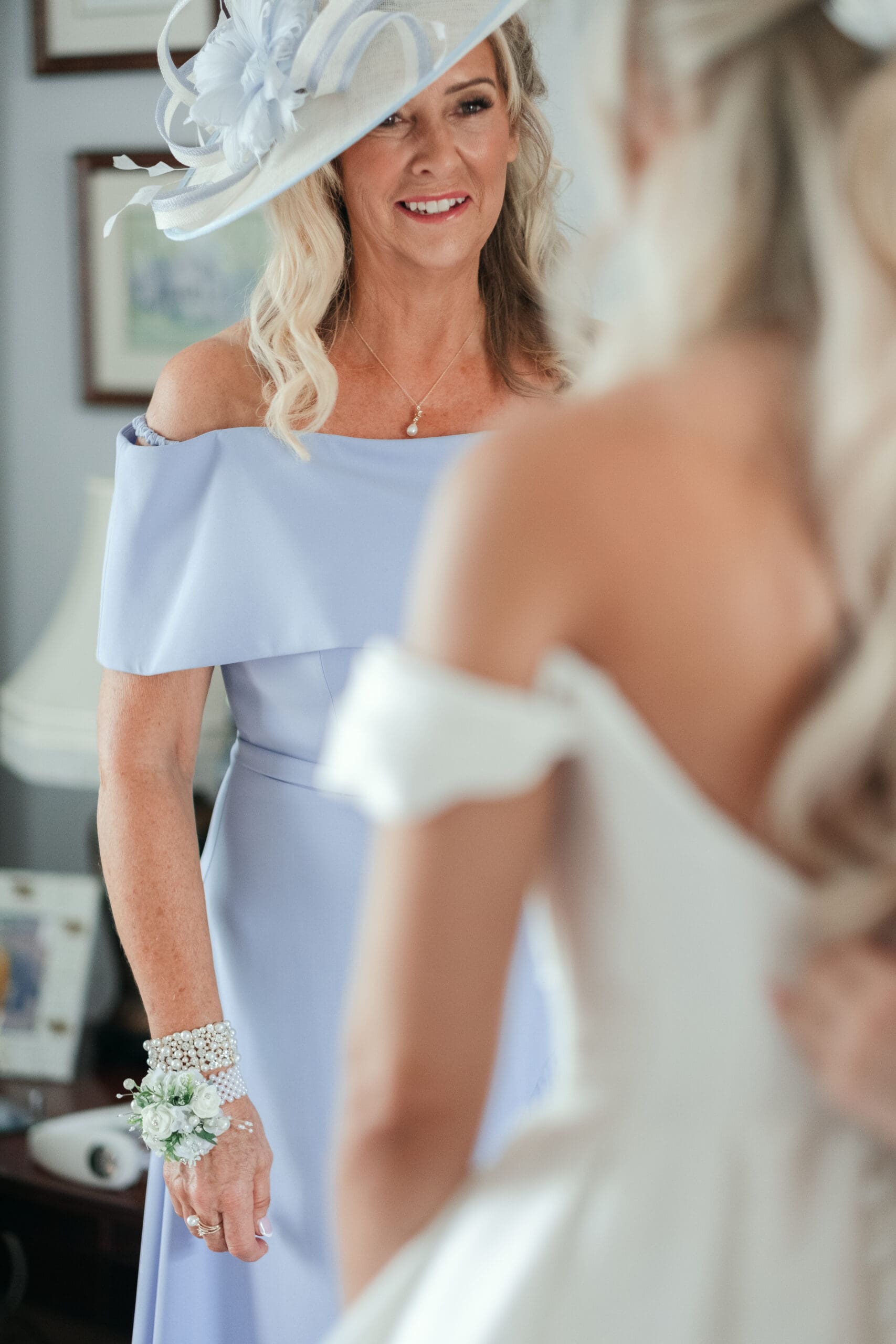 Emotional moment of mother fastening bride’s dress before the ceremony at St Paul’s Church Gorefield.