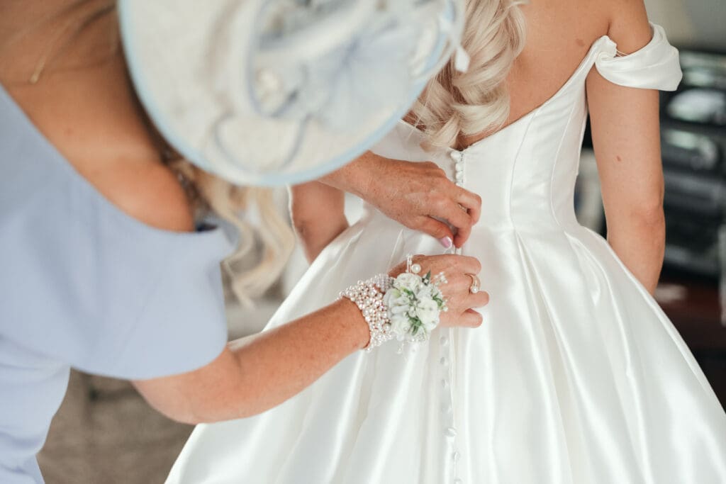 Bride’s mother helping her into her wedding dress during morning prep at a Wisbech wedding